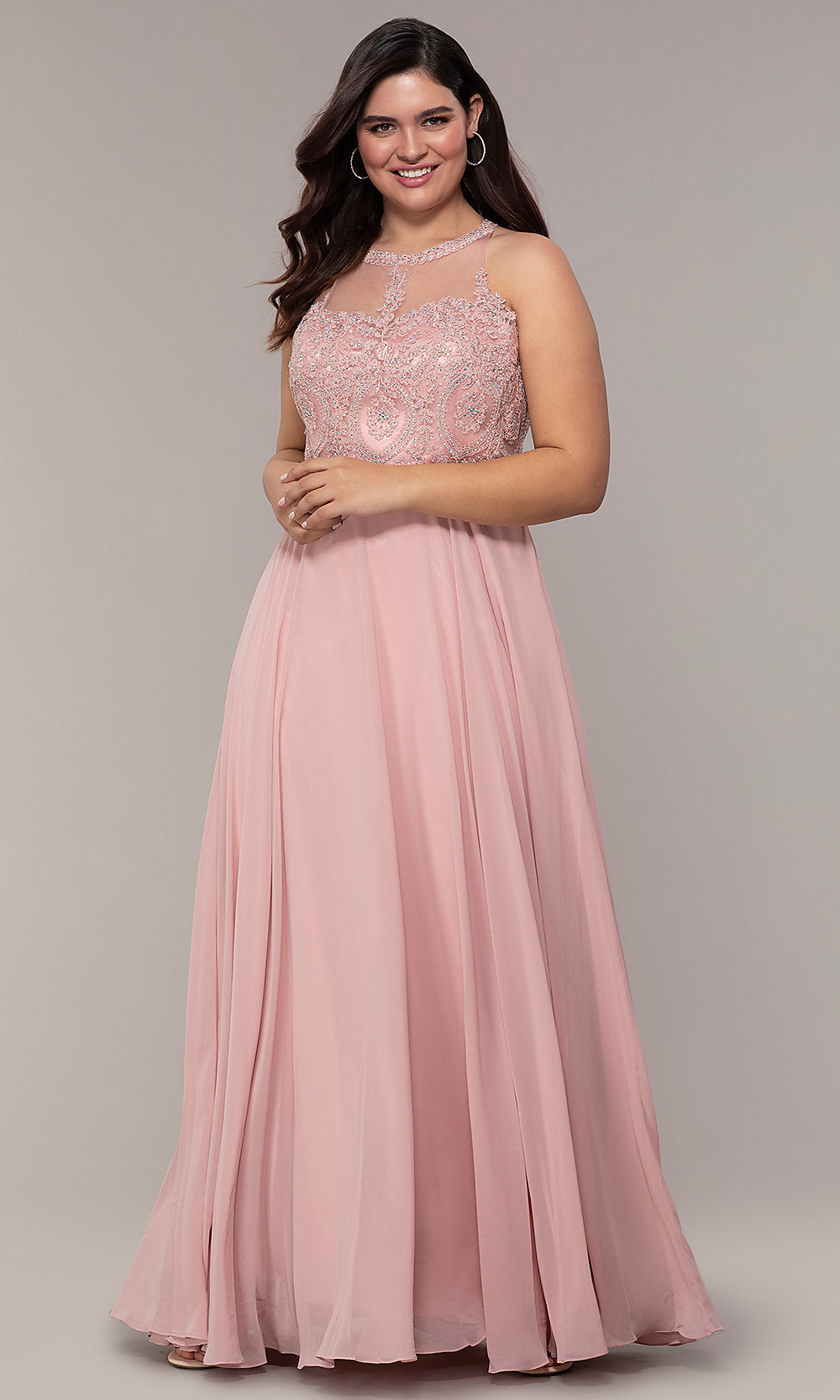 A woman poses against a plain background in the Long Chiffon Embroidered-Bodice Prom Dress, featuring a sleeveless, floor-length blush pink chiffon design with an embroidered bodice.